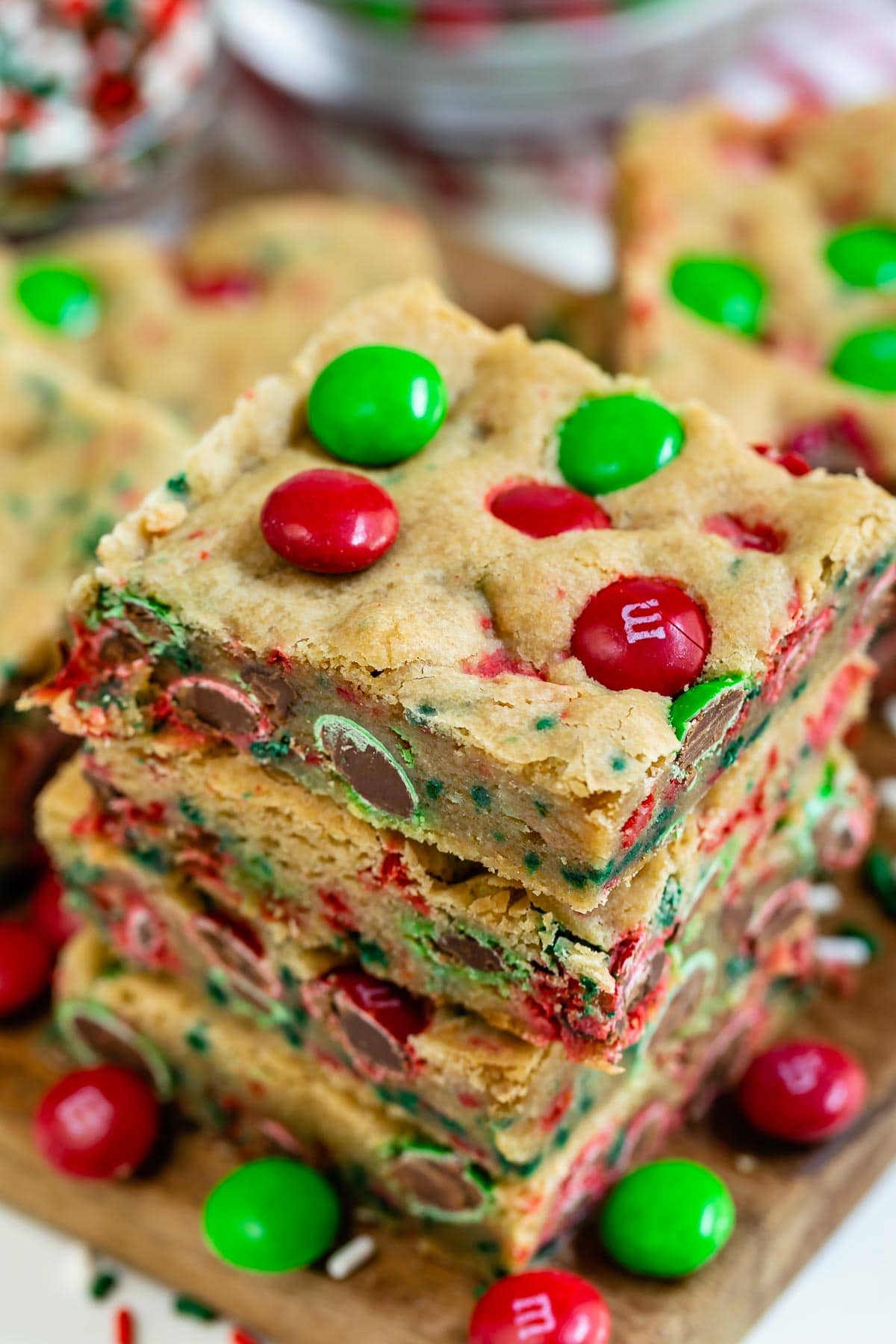 Overhead view of three christmas cookie bars stacked on eachother with m&ms all around