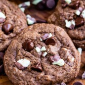 Overhead view of double chocolate mint cookies with andes mints scattered around cookies