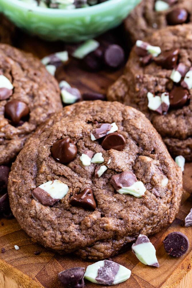 Overhead view of double chocolate mint cookies with andes mints scattered around cookies