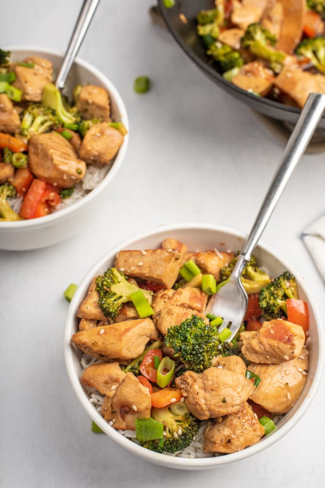 Overhead view of chicken teriyaki in two white bowls ready to eat