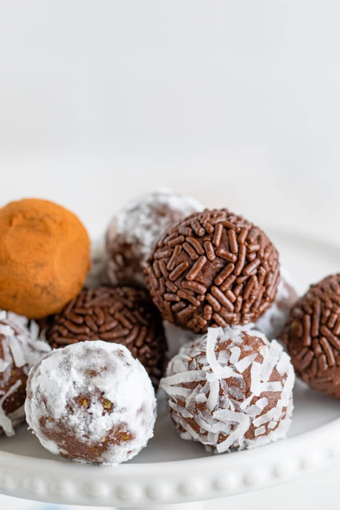 Plate full of chocolate avocado truffles with different toppings