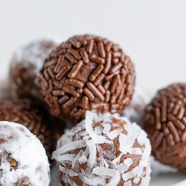 Close up shot of chocolate avocado truffles with sprinkles and coconuts on the outside