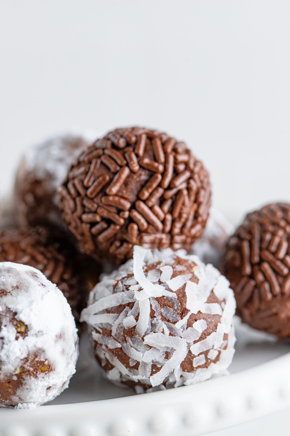 Close up shot of chocolate avocado truffles with sprinkles and coconuts on the outside