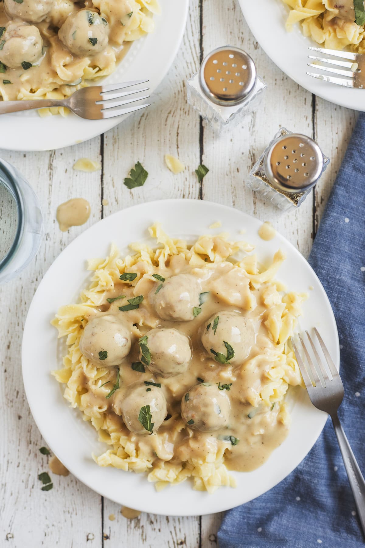 meatballs on plate with egg noodles and fork.