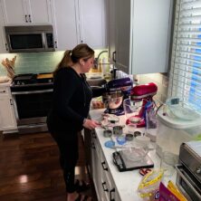 woman in kitchen with mixers and ingredients all around her