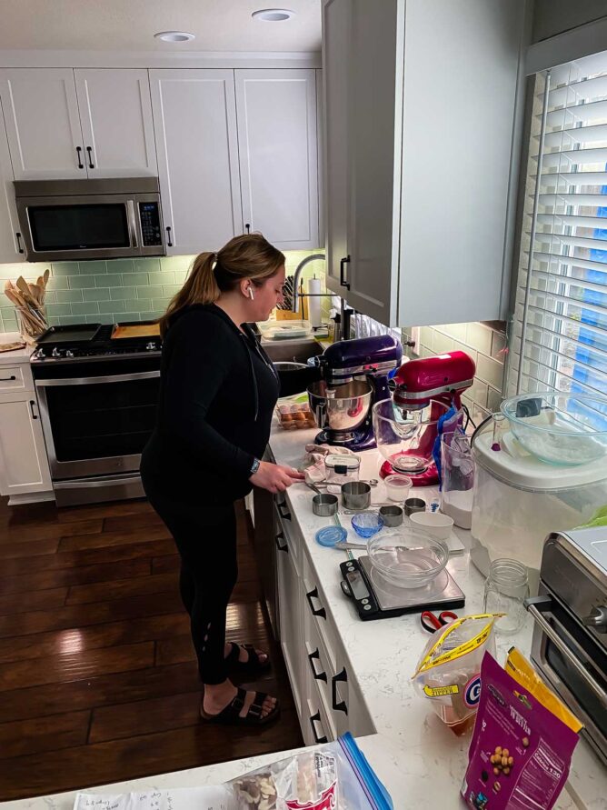 woman in kitchen with mixers and ingredients all around her