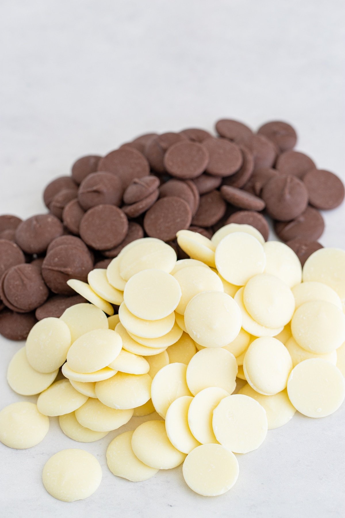 chocolate and white chocolate melting wafers on marble surface