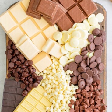 overhead shot of different kinds of chocolate on wood cutting board with words on photo