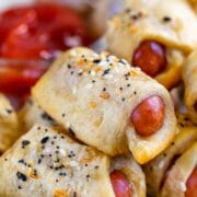 Close up of everything pigs in a blanket stacked on eachother on a plate