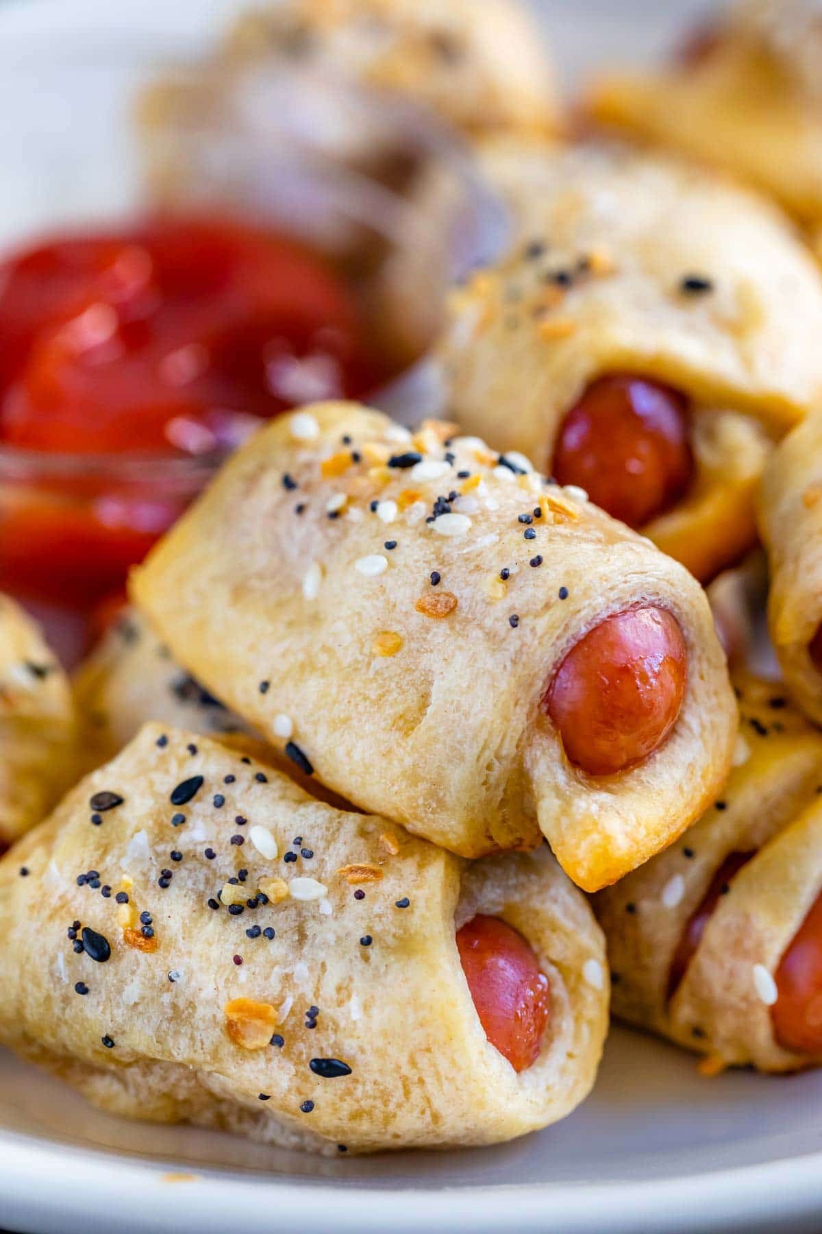 Close up of everything pigs in a blanket stacked on eachother on a plate