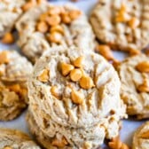 Peanut butter butterscotch cookies stacked on eachother with more surrounding them