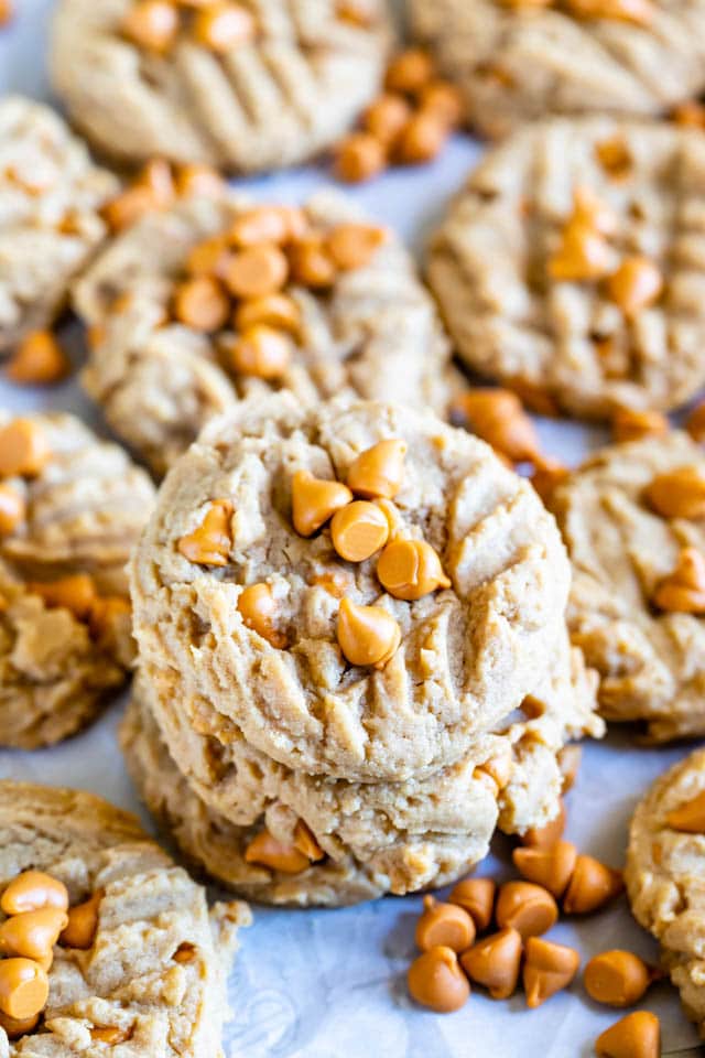 Peanut butter butterscotch cookies stacked on eachother with more surrounding them