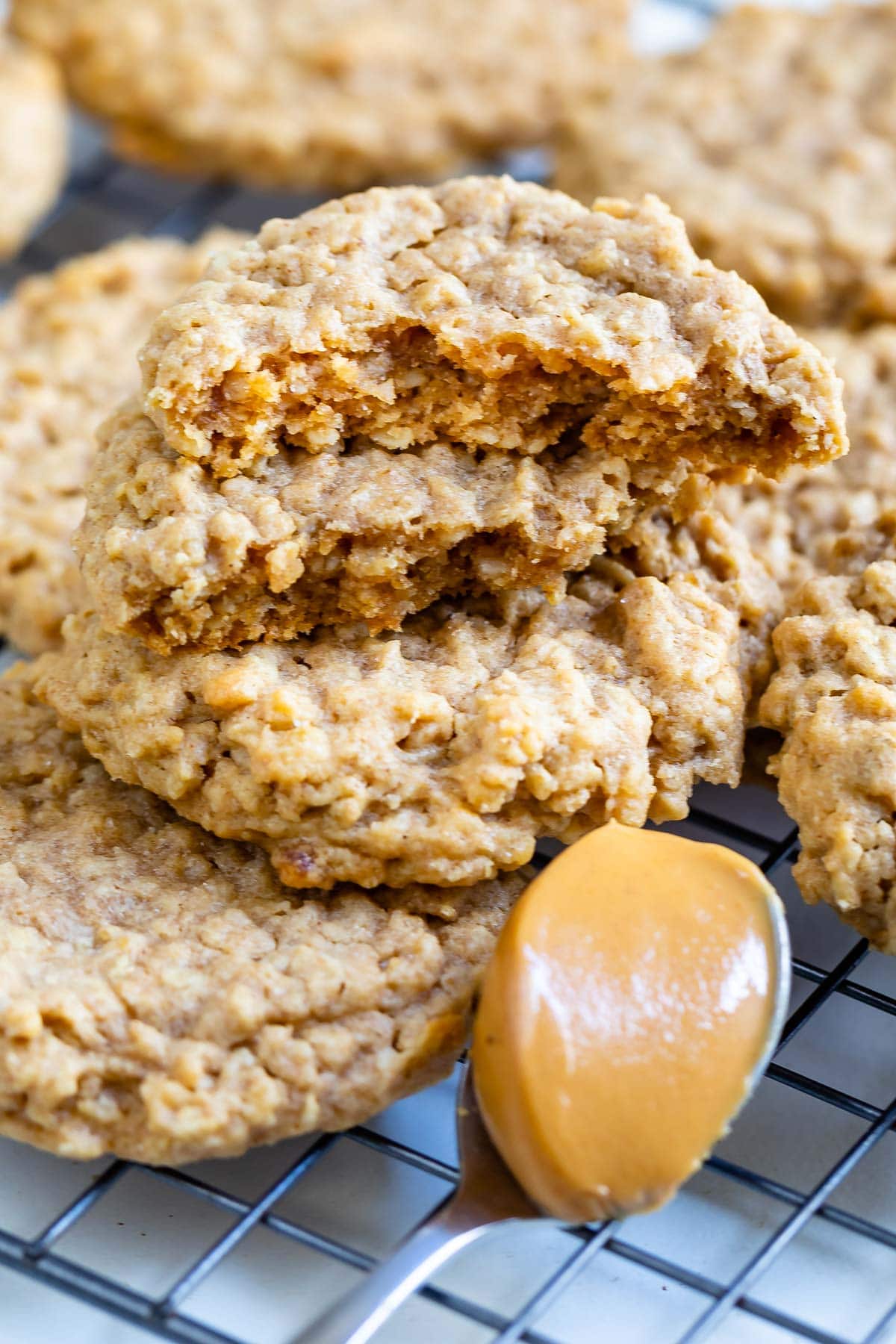 Peanut butter oatmeal cookies stacked on eachother with top cookie cut in half to show inside