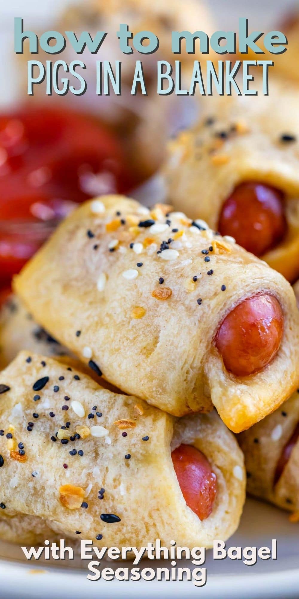 Close up of everything pigs in a blanket stacked on eachother on a plate with recipe title on top of image