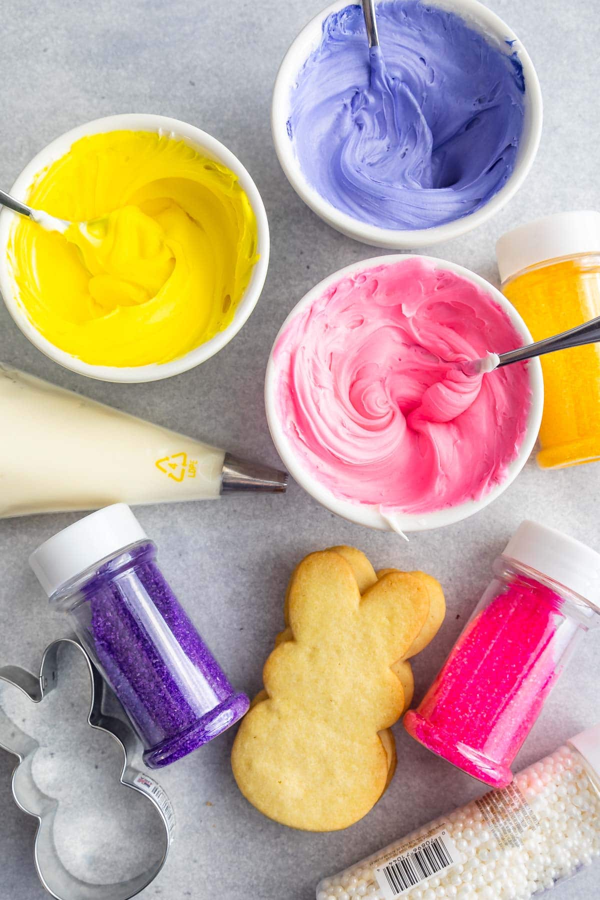 Overhead shot of bunny sugar cookies, frosting and decorating sprinkles