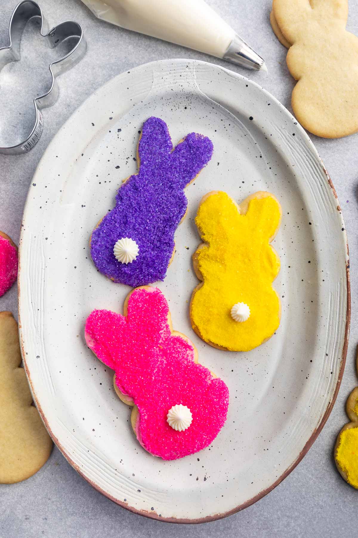 Overhead shot of three decorated bunny cookies on a white serving plate