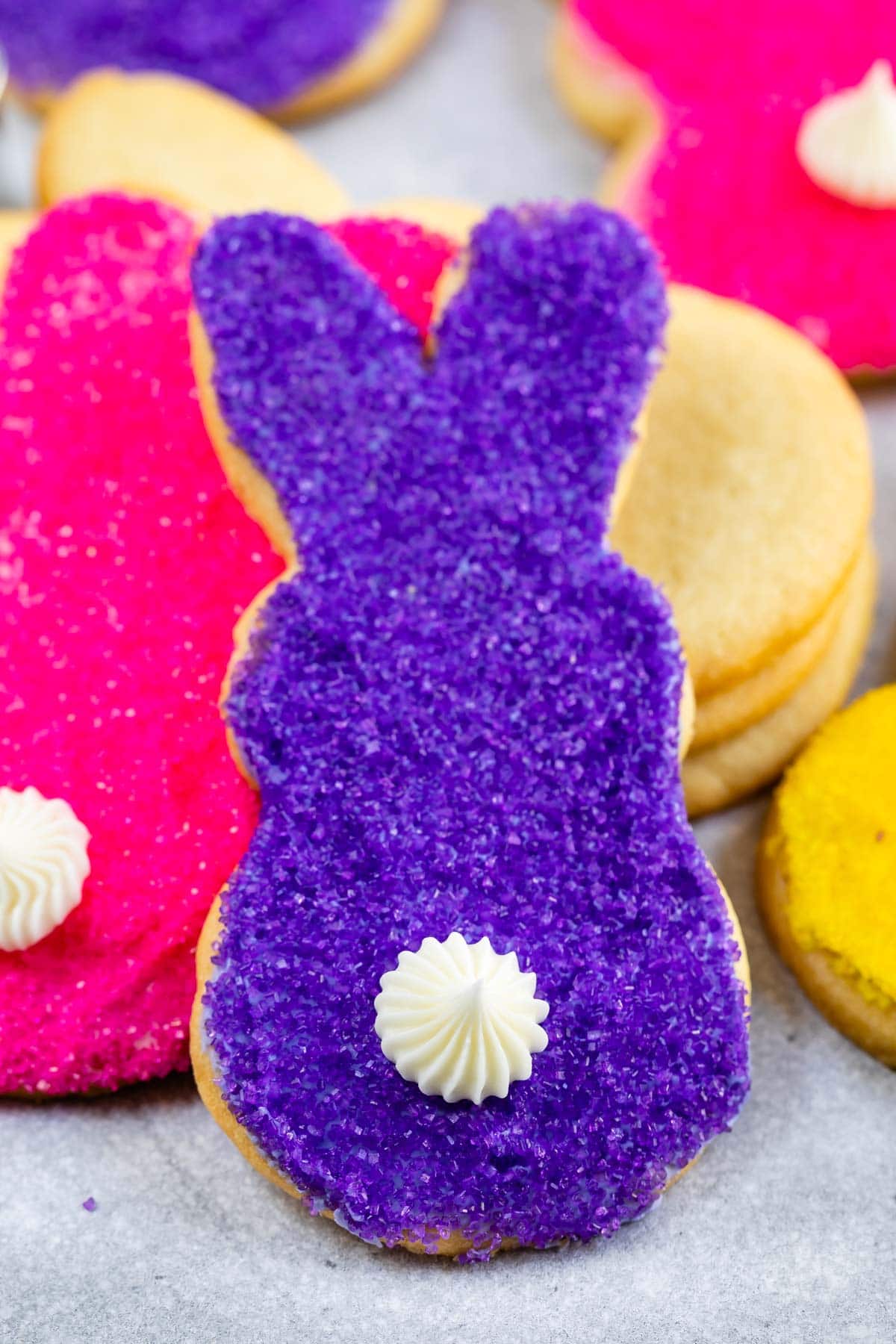 Close up shot of purple and pink bunny butt cookies with white icing tail