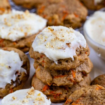 Carrot cake cookies stacked on eachother with top one covered in cream cheese frosting