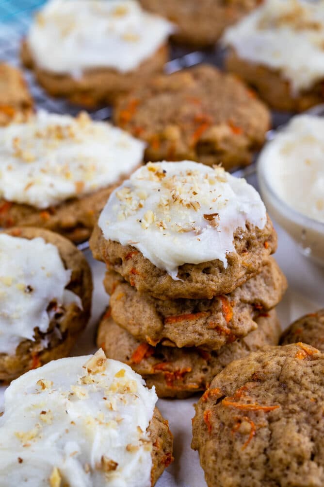 Carrot cake cookies stacked on eachother with top one covered in cream cheese frosting
