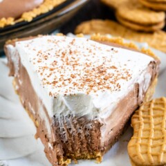 Close up of one slice of chocolate cream pie on a plate with one bite missing