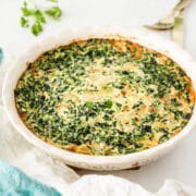 Spinach crustless quiche in a white serving dish after being cooked