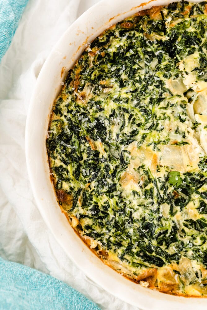 Overhead shot showing one half of the spinach crustless quiche in its baking dish