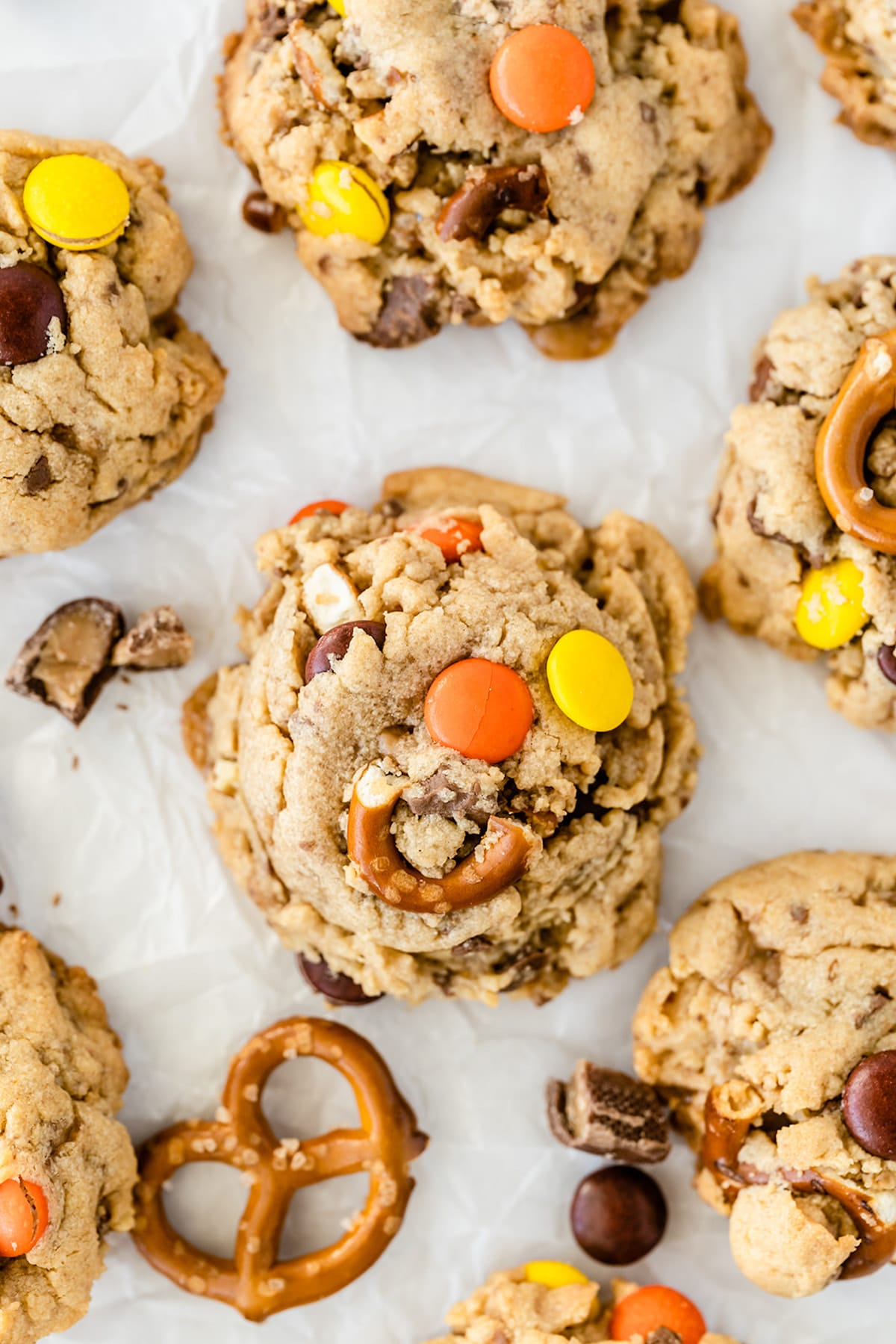 Overhead close up photo of toffee pretzel peanut butter cookies on parchment paper