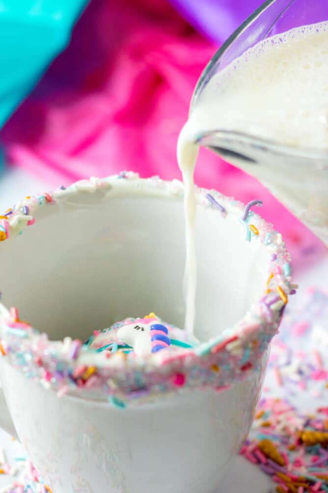 Milk being poured over a white hot chocolate bomb