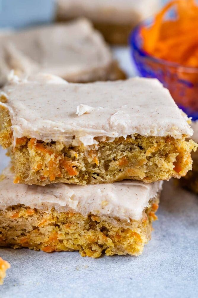 Stack of two carrot cake blondies on parchment paper