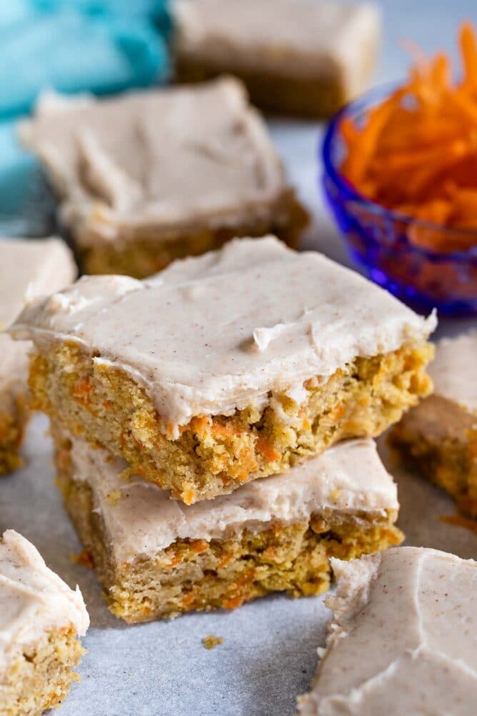 Stack of two carrot cake blondies on parchment paper