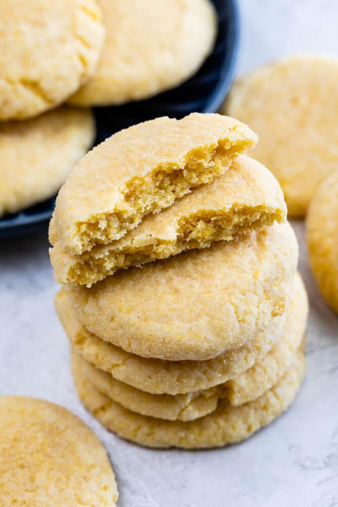 Cornmeal cookies stacked on eachother with the top cookie cut in half