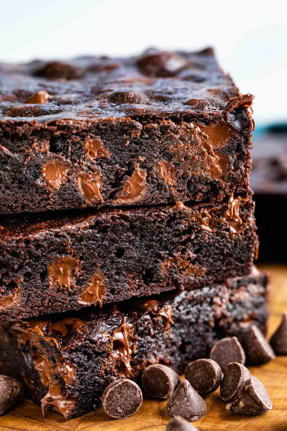 Stack of dark chocolate brownies with chocolate chips around them