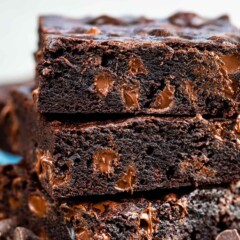 Stack of dark chocolate brownies with chocolate chips around them