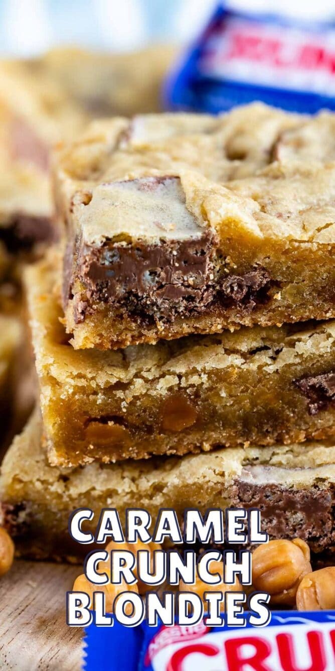Stack of caramel crunch blondies with crunch candy bars next to it and recipe title on bottom of image