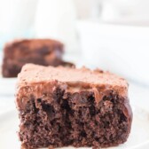 One slice of chocolate poke cake on a white plate