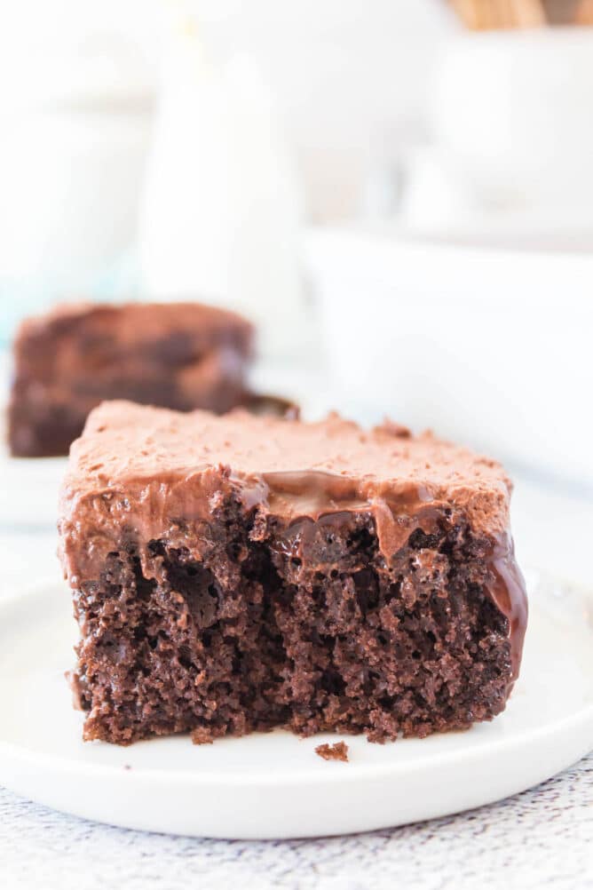 One slice of chocolate poke cake on a white plate