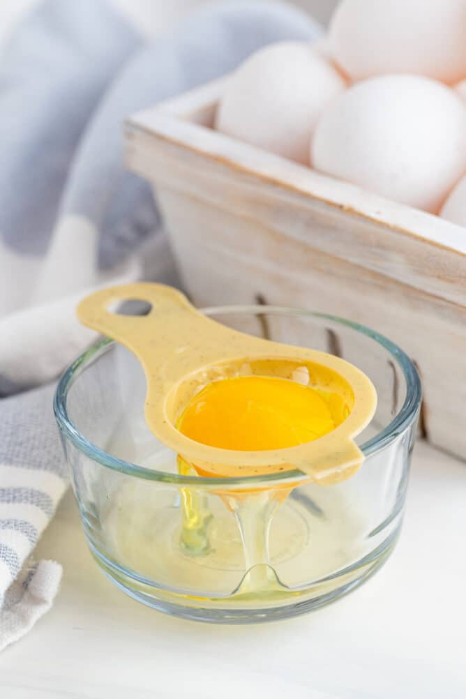 One egg being separated into a small bowl using an egg separator tool