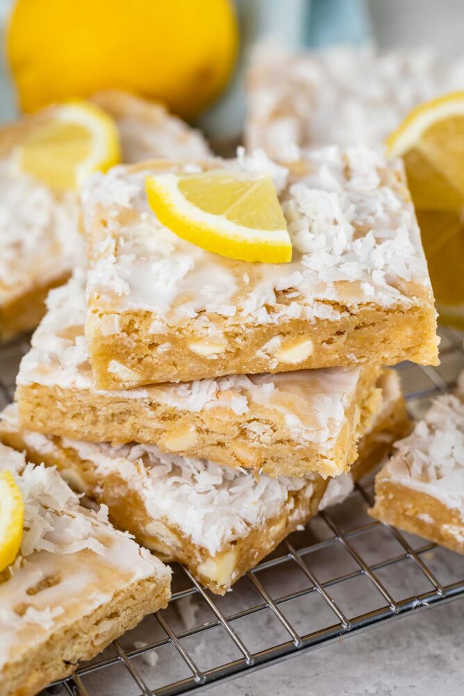 Stack of three lemon coconut blondies with a lemon slice on top