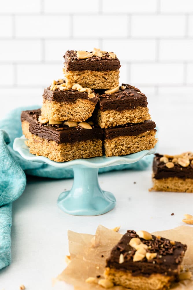 Peanut butter cookie fudge bars cut into squares and placed on a turquoise cake stand