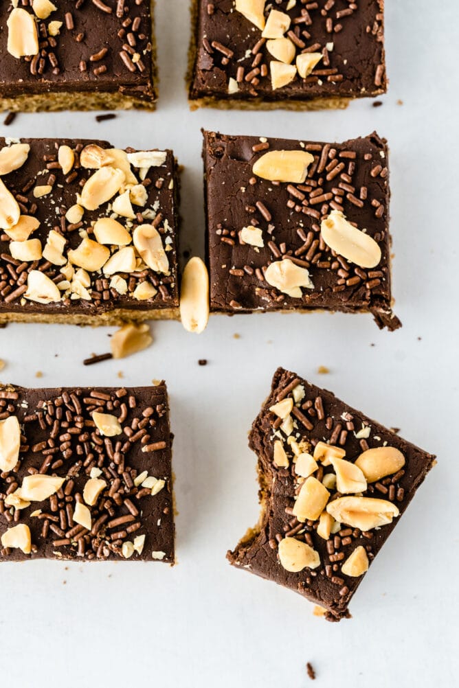 Overhead shot of peanut butter cookie fudge bars cut into squares with one missing a bite