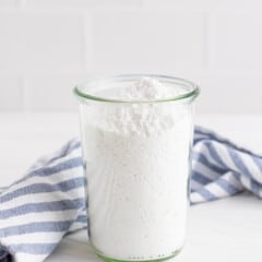 Side view of powdered sugar in a tall clear glass