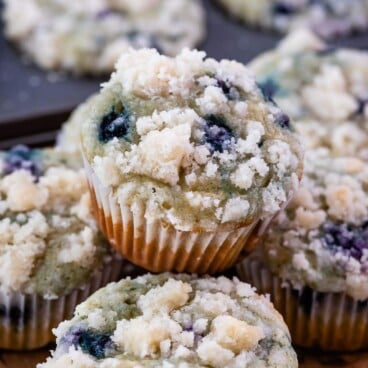 blueberry muffin sitting on stack of muffins