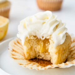A perfect triple lemon cupcake cut in half to show lemon curd filling
