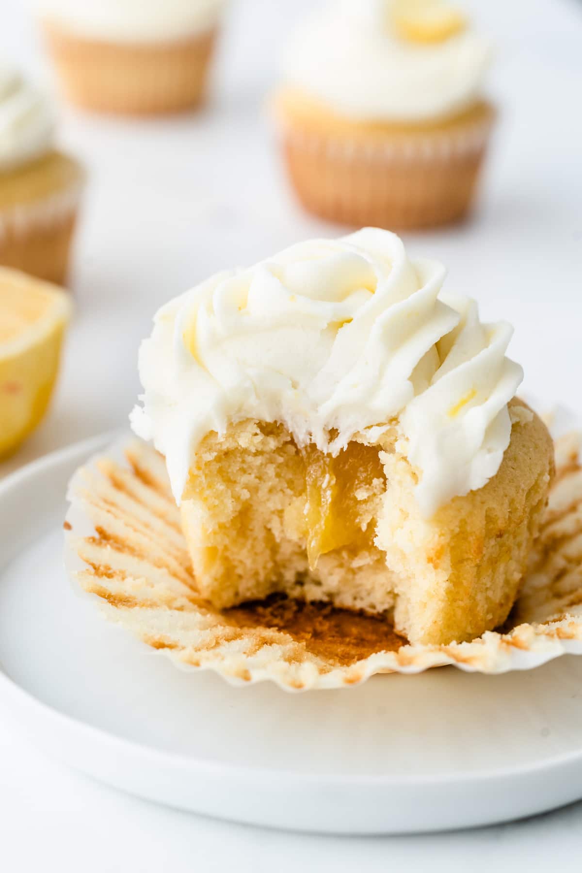 A perfect triple lemon cupcake cut in half to show lemon curd filling