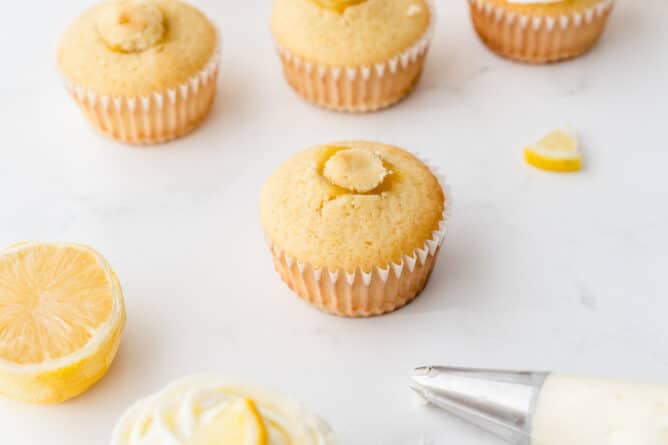Perfect triple lemon cupcakes with tops put back on after being filled with lemon curd