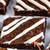 Close up shot of carrot cake brownies cut into squares with a cream cheese glaze with recipe title on top of image