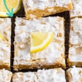 Overhead shot of lemon coconut blondie squares on a wire cooling rack with lemon wedges on top and recipe title on top of image