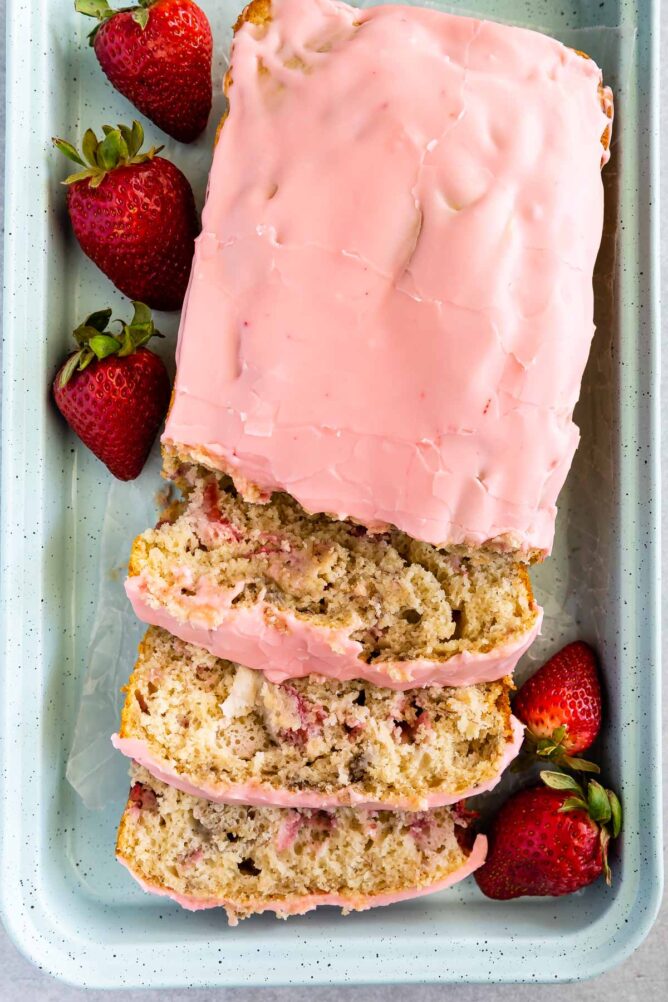 overhead shot of sliced banana bread with pink frosting