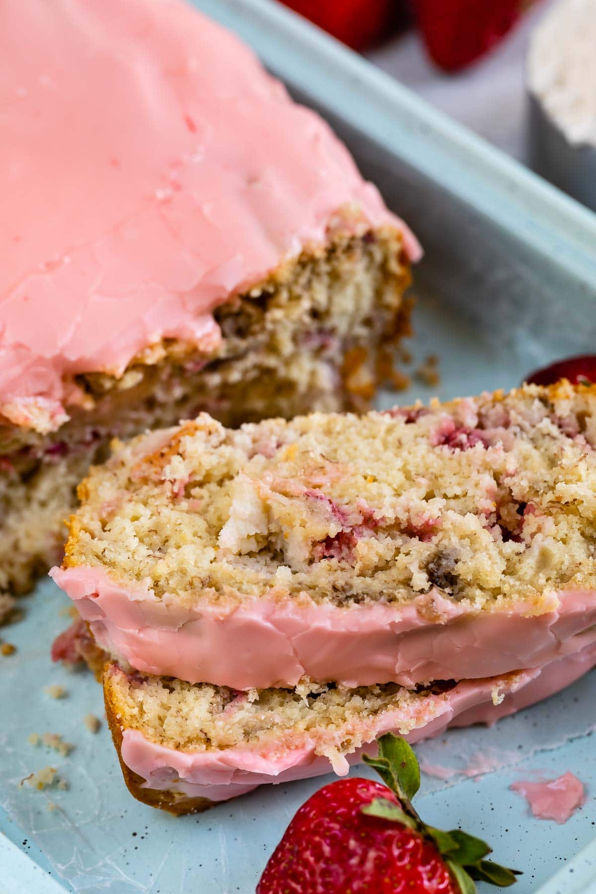 two slices of bread with pink frosting on teal tray