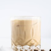 Side shot of white russian in a cocktail glass with coffee beans around it
